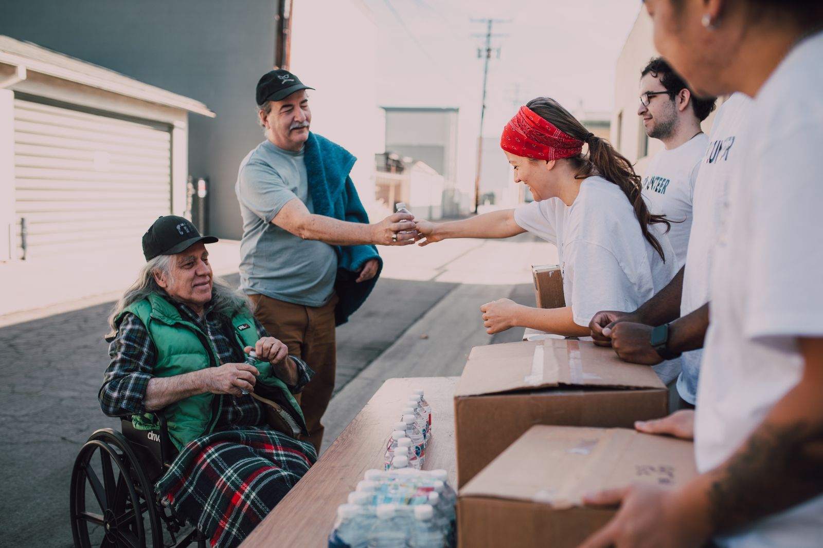 People distributing water and supplies outdoors