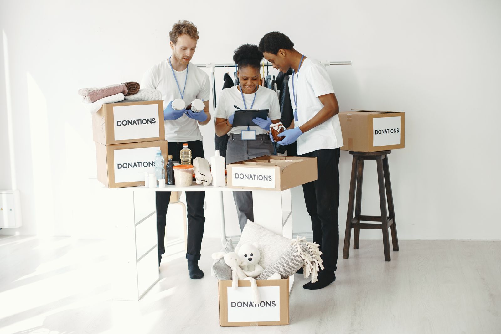 Volunteers organizing boxes of donated essentials indoors