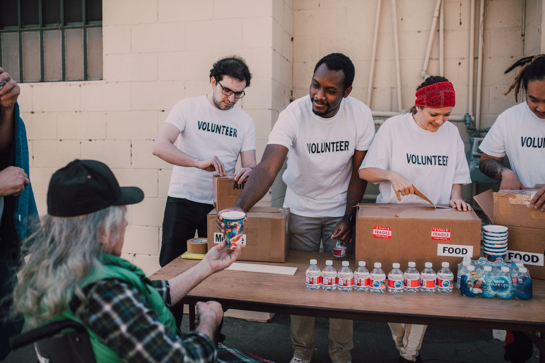 Volunteers distributing food and drinks at an outdoor support event